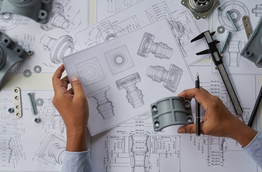 Technicien Supérieur en Conception Industrielle de Systèmes Mécaniques analysant une pièce mécanique et un dessin industriel de pièce mécanique pour l'obtention de son titre professionnel lors de sa formation